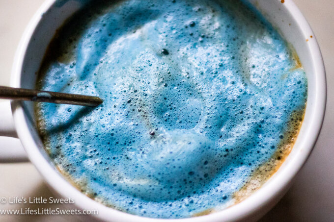 a blue frothy milk and espresso drink in a white mug