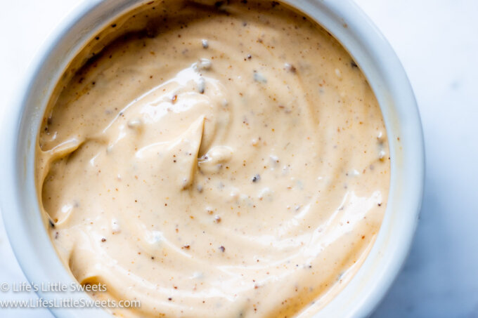 mayonnaise with chili crisp in a white bowl with a white marble background