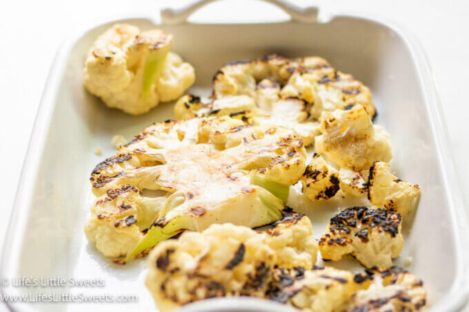 grilled cauliflower in a white serving platter on a white background