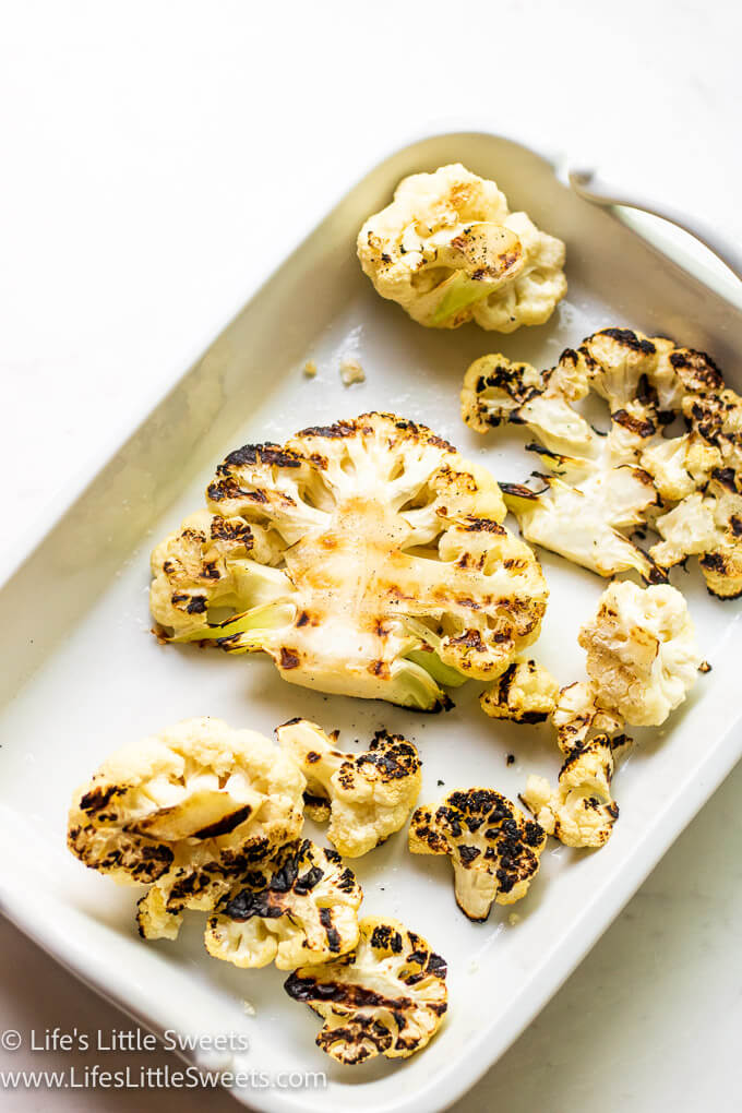 cooked cauliflower in a white rectangular platter over a white background
