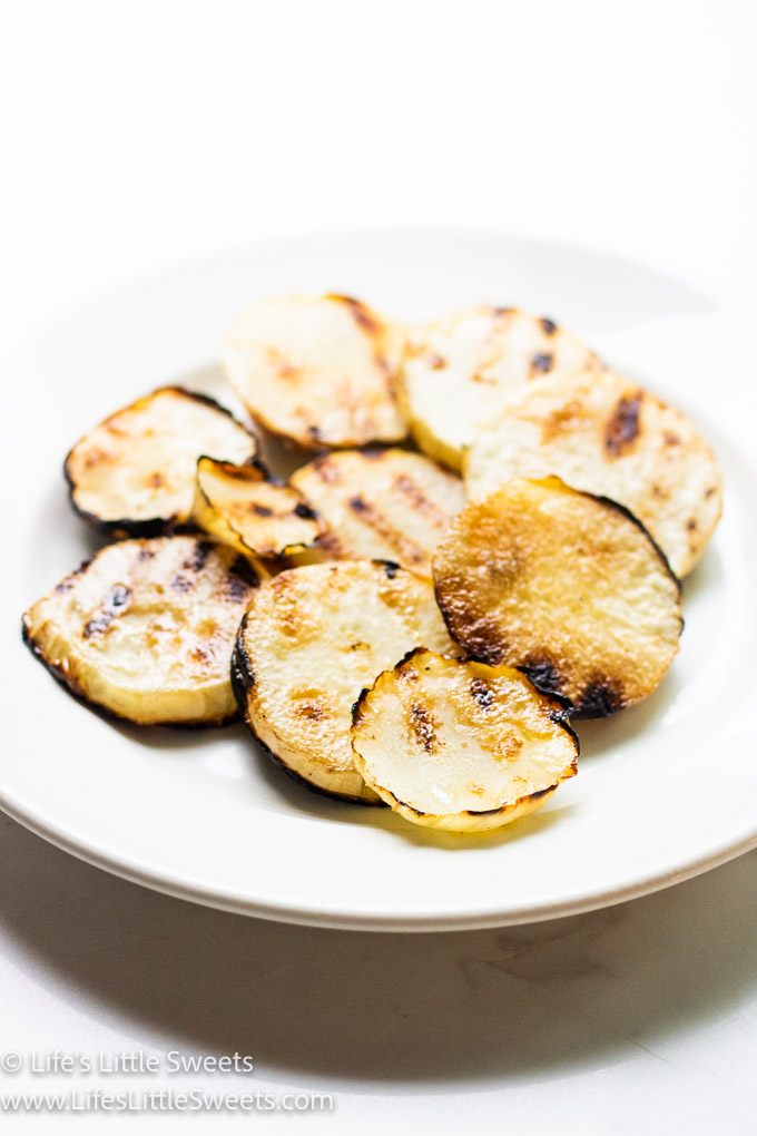 grilled kohlrabi on a white plate over a marble table