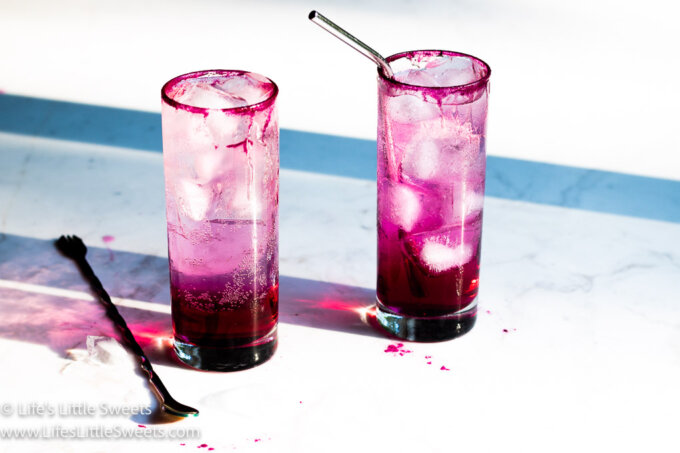 2 pink icy drinks with a straw and a cocktail spoon