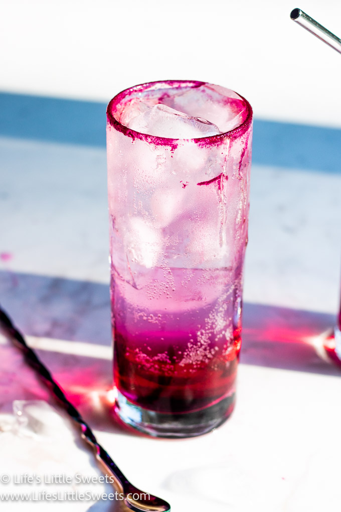 1 cold pink drink with ice on a white marble table