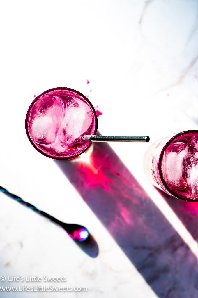 overhead view of 2 pink icy cold drinks on a white marble table