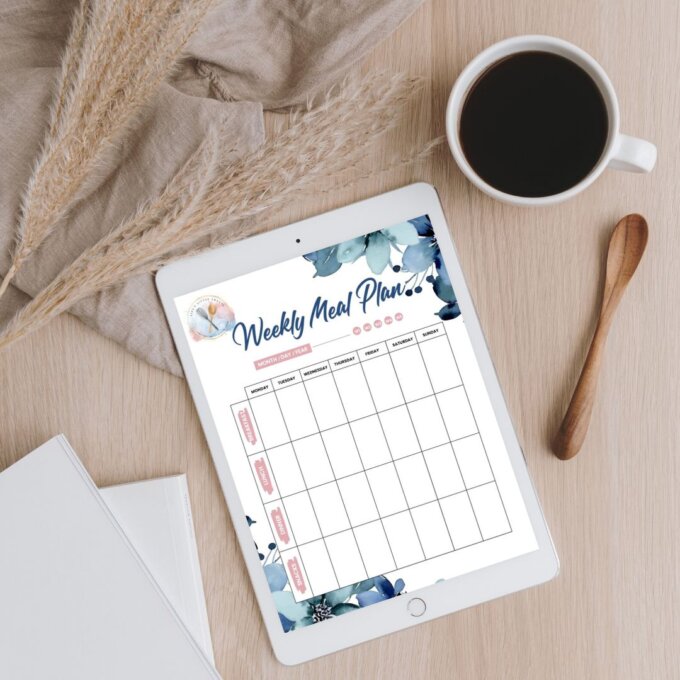 Weekly meal plan planner on an iPad over a wood desk