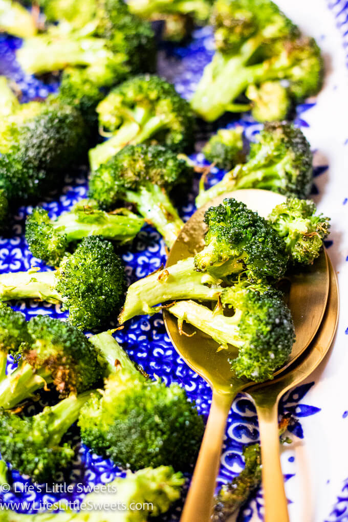 Air-Fryer Broccoli florets with gold spoons on a blue and white plate