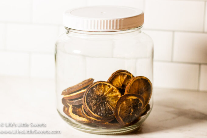 dried oranges in slices in a clear jar in a white kitchen