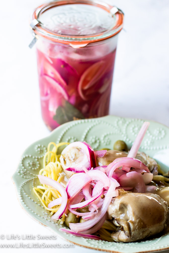 pickled red onions in a jar and on a dinner