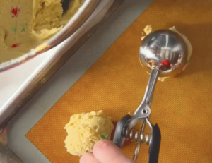 scooping cookie dough balls using a large cookie scoop