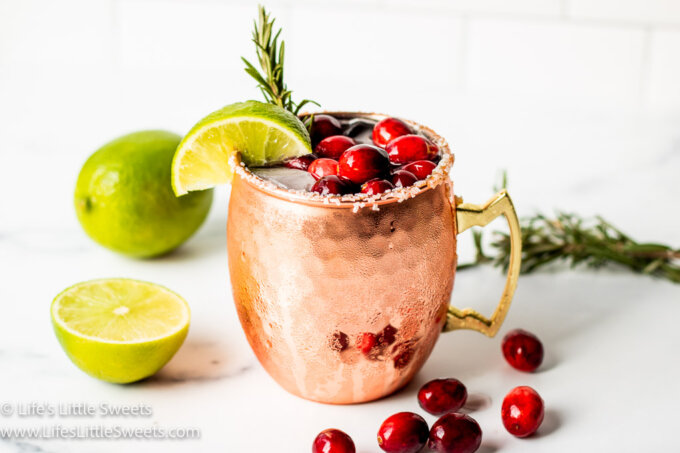 a holiday gin mule with fresh cranberries, a sprig of rosemary, lime and ice
