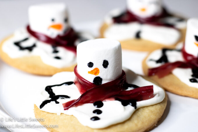 several melted snowman cookies with a red scarf