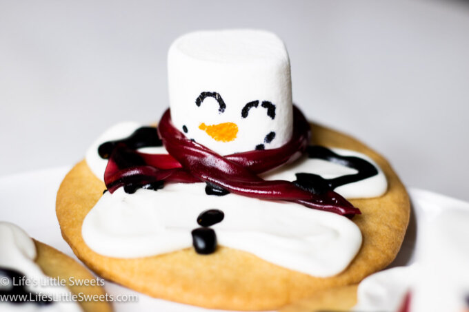 a melting snowman cookie on a white background