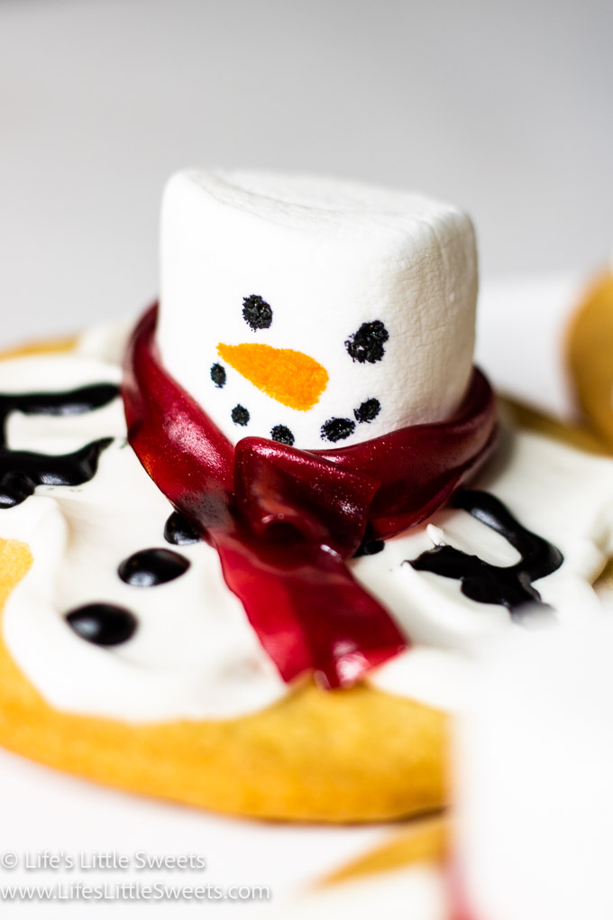 a snowman cookie that has a scarf