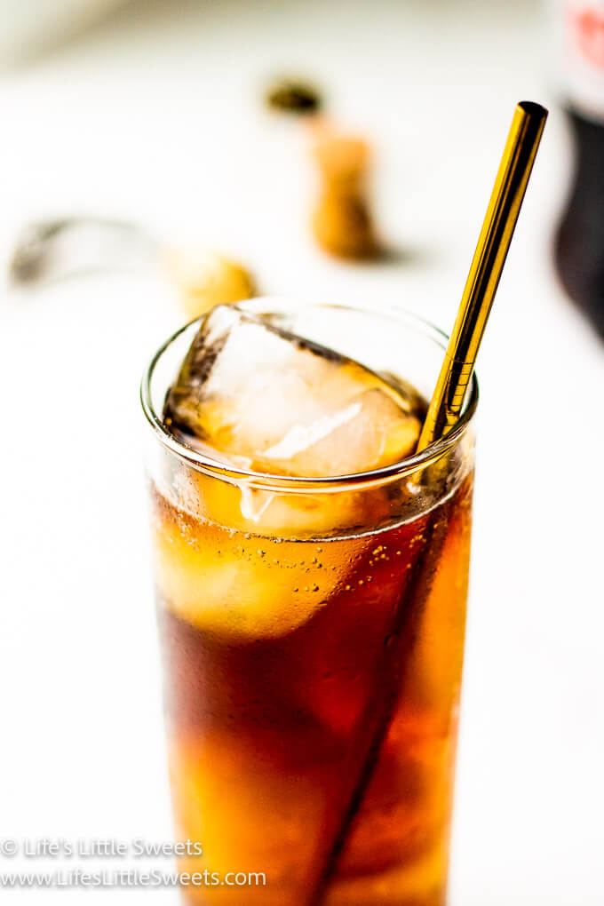 brown cola drink with gold straw