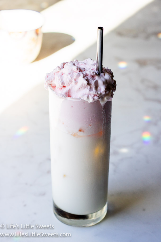 a fluffy white and pink drink with rainbows