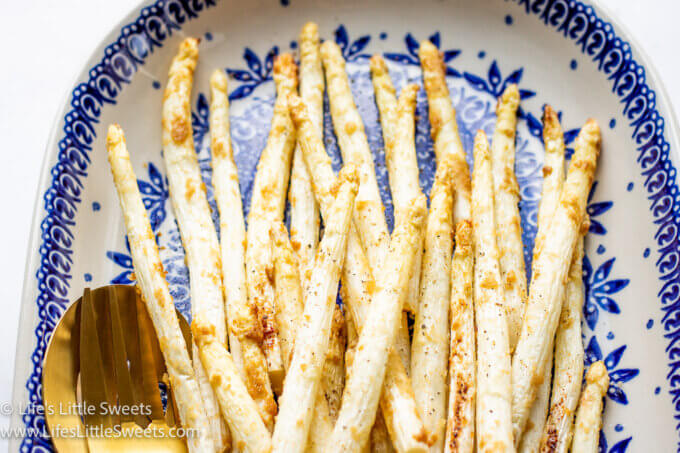 Air Fryer White Asparagus on a white and blue plate with gold utensils