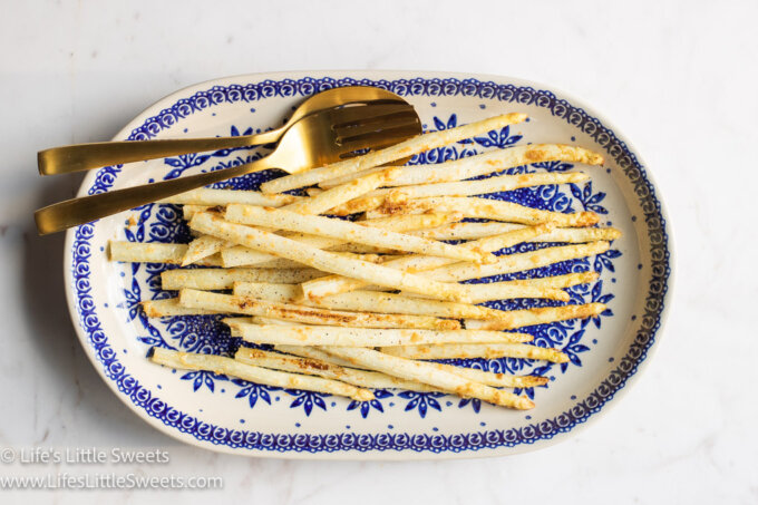 overhead view of cooked white asparagus with gold utensils