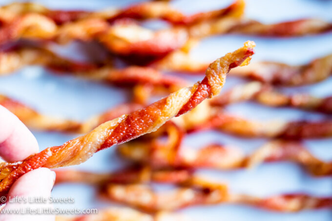 holding up a twist of bacon