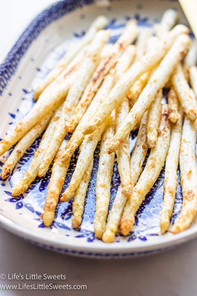 angled view of white asparagus on a blue and white plate