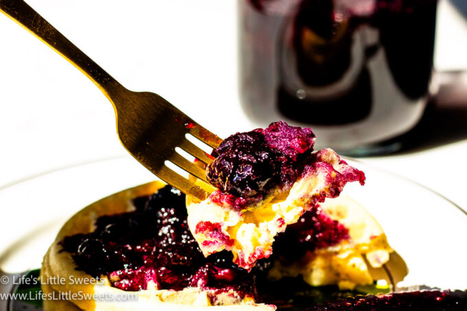 a forkful of waffles with blueberry syrup