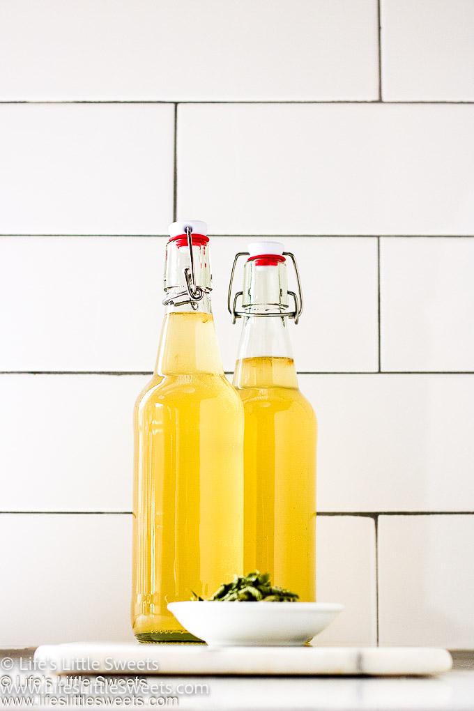 Yellow Lemon Verbena Kombucha  in clear glass bottles