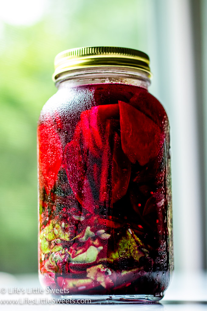 a large jar of pickled red beets on a marble table