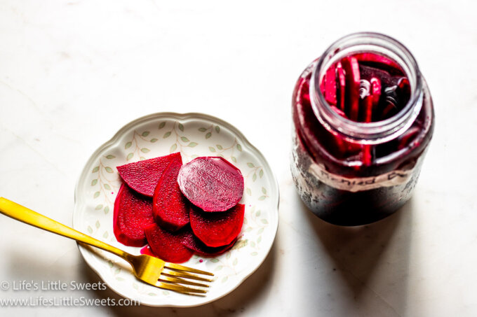 a jar of pickled beets with a plate of pickled beets with a gold fork