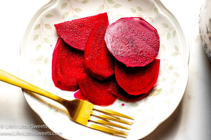 pickled beets on a plate with a gold fork
