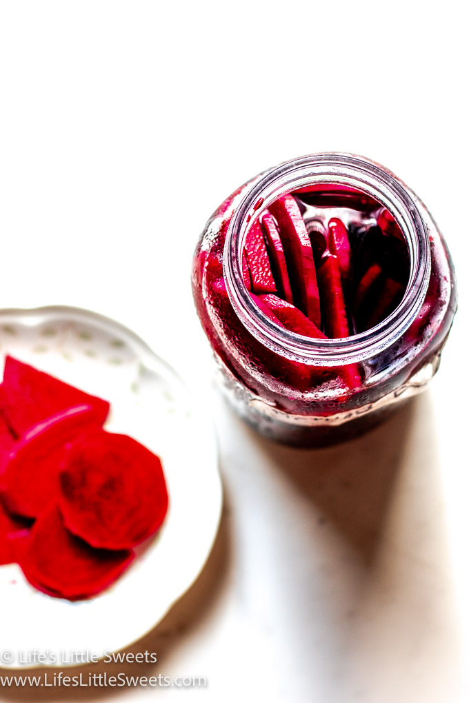 an open jar of pickled beets with a plate of beet slices