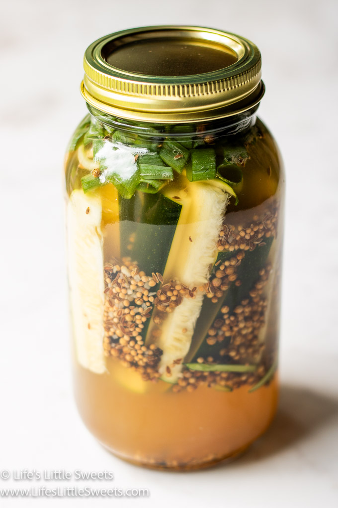 Pickled Zucchini (How to Pickle Zucchini) in a glass jar with water, vinegar and pickling spices