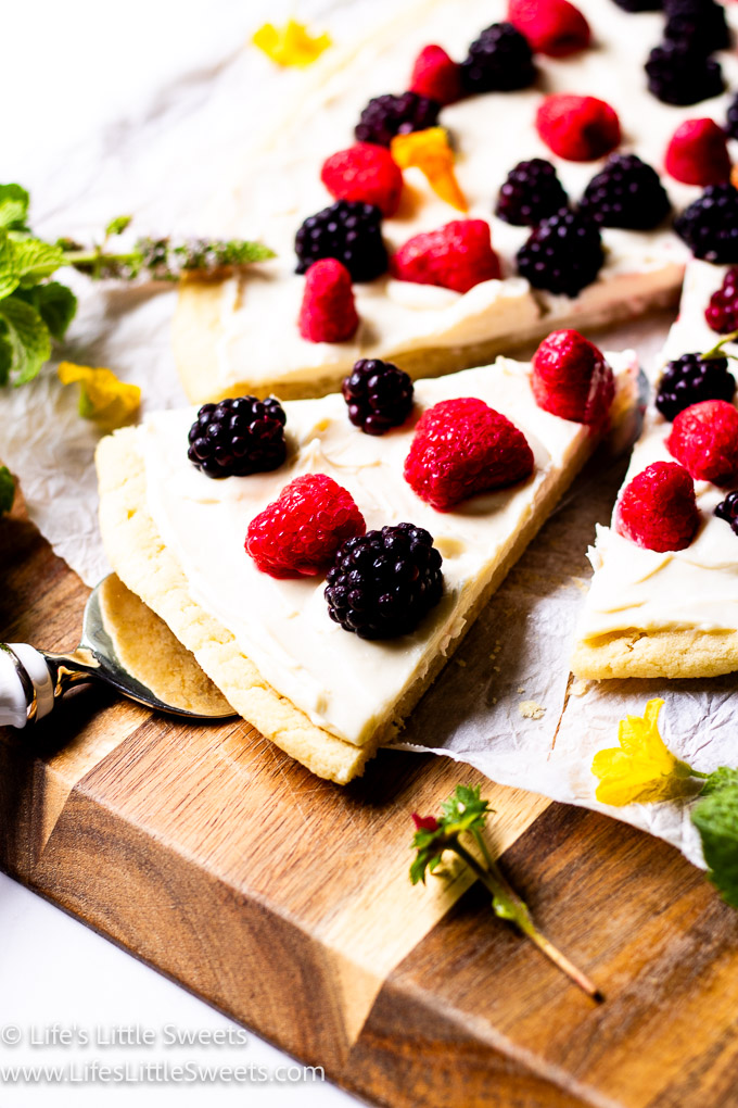 fruit pizza with fresh berries on top with a cut slice