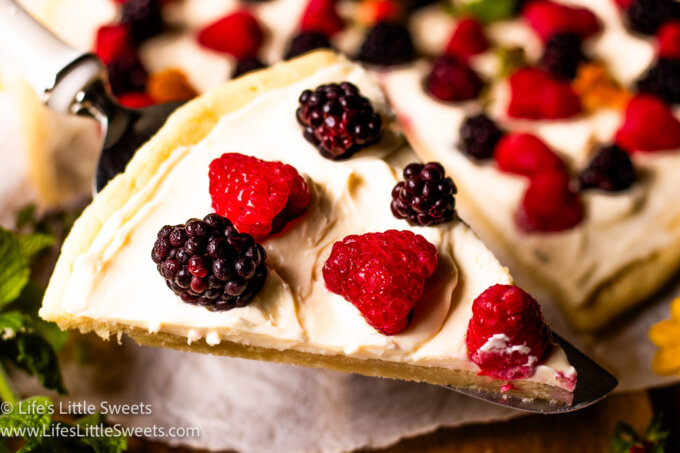 a slice of fruit pizza with fresh berries on top
