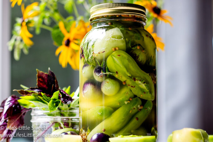 pickled green tomatoes in a mason jar on a white marble table 