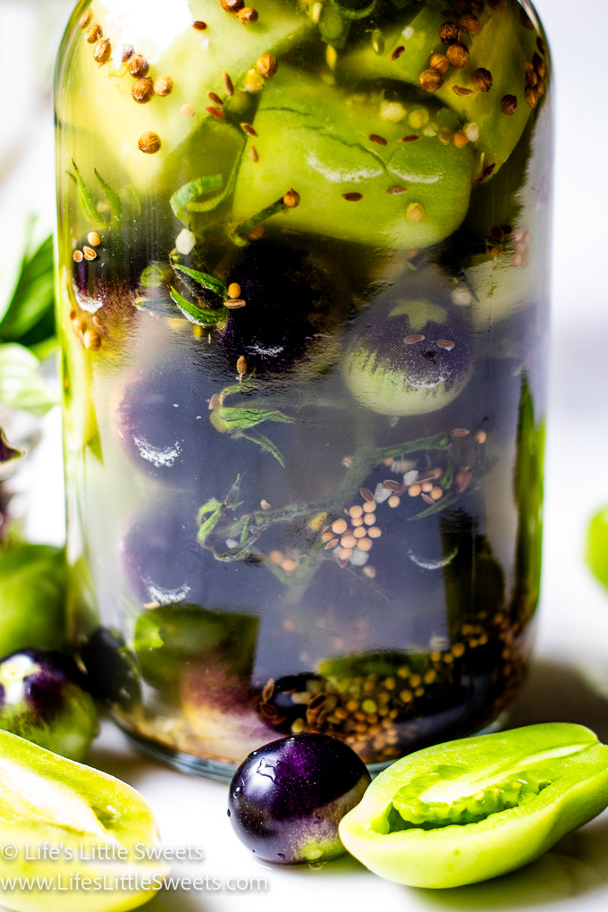 close up of pickled green tomatoes in a mason jar