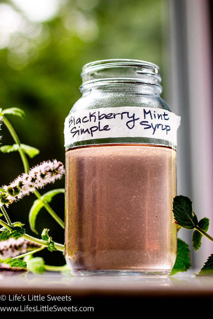 a purple simple syrup in a mason jar with fresh mint