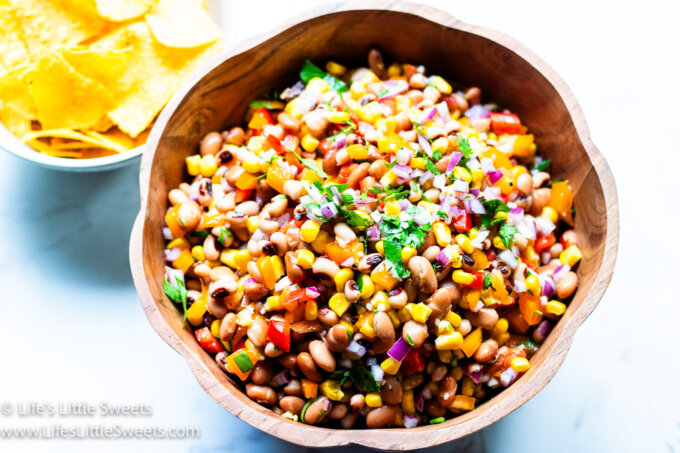 a bowl of Cowboy Caviar with chips in the background