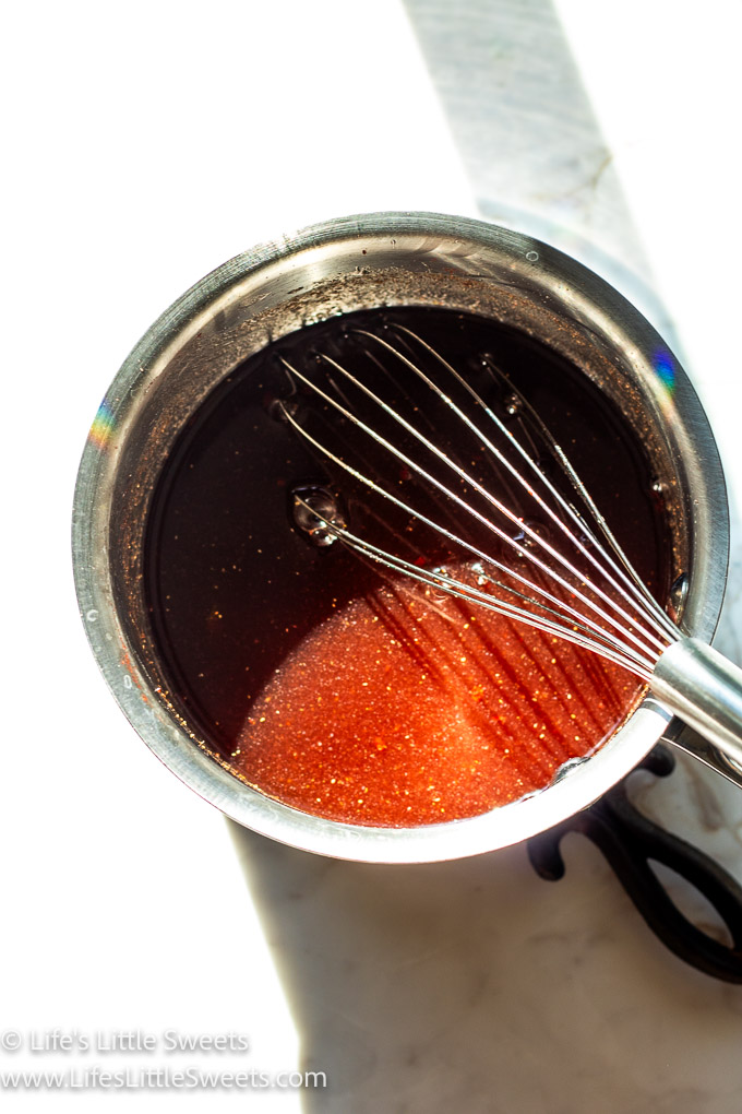 Strawberry Simple Syrup Recipe in a saucepan with a whisk