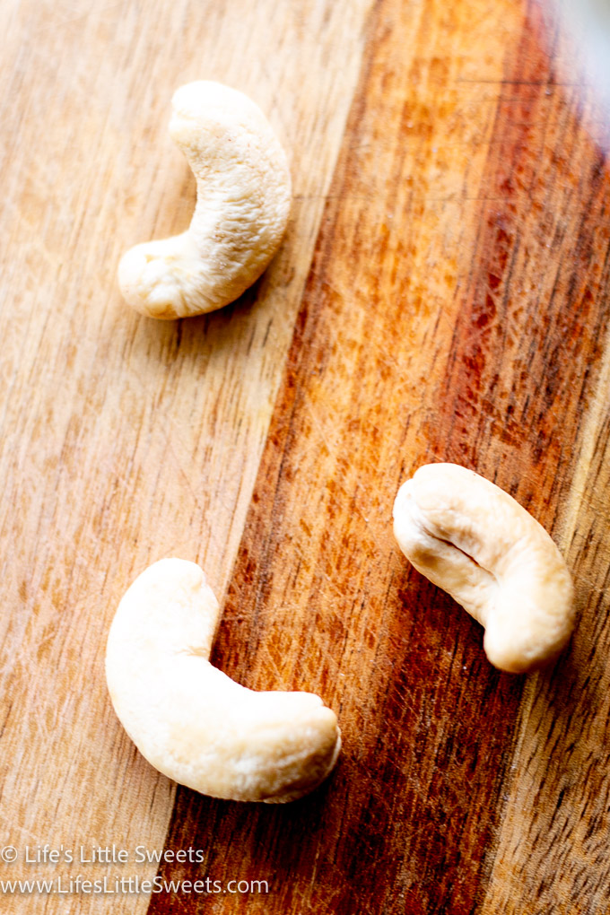 raw cashews on a wood cutting board