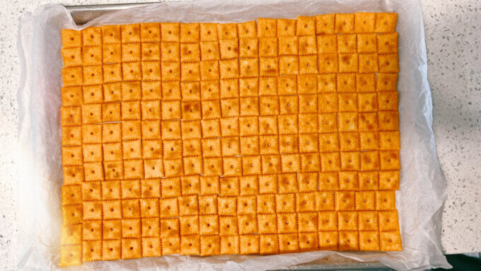 Regular Cheez-Its arranged on a parchment-lined baking sheet