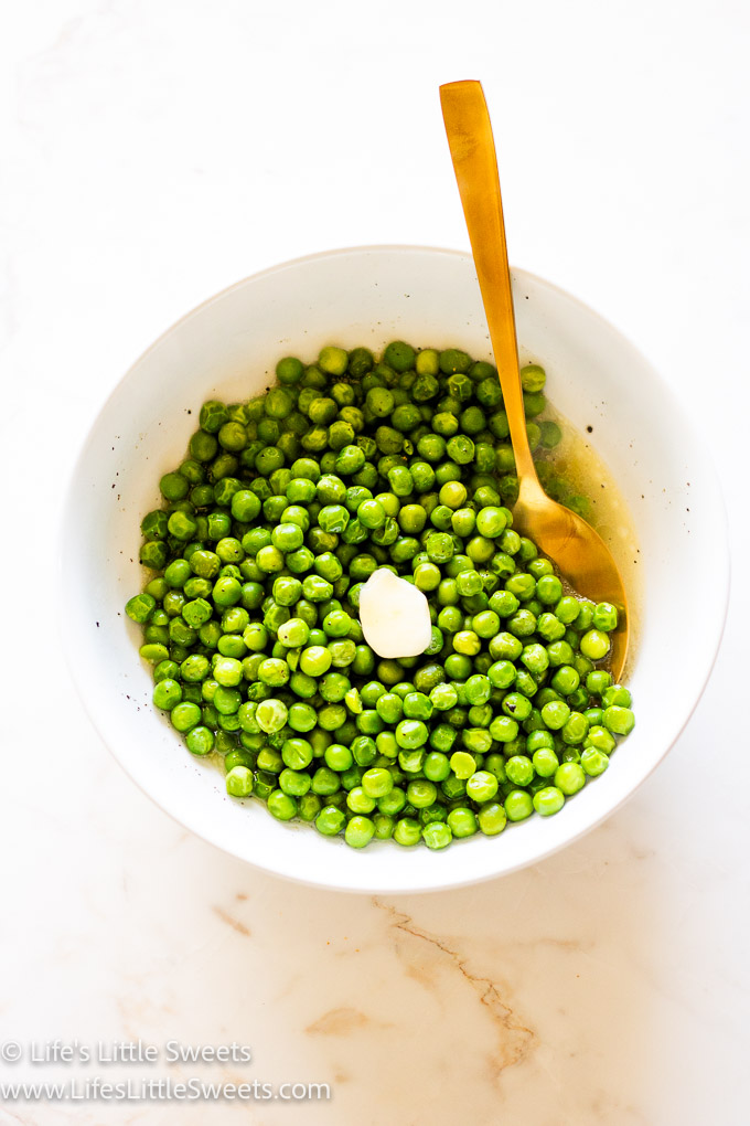 Slow Cooker Crock Pot Butter Green Peas in a white bowl with a gold spoon and pt of butter