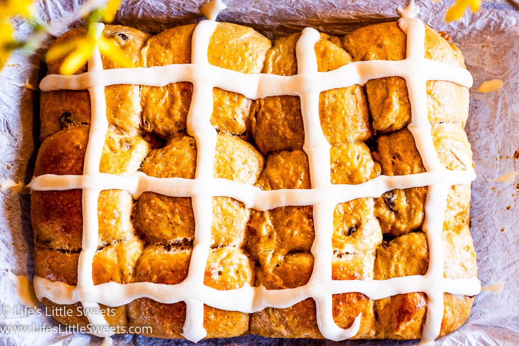 overhead view of hot cross buns in a 9x13-inch pan, lined with parchment paper