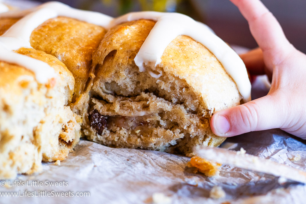 close up of a hot cross bun being taken